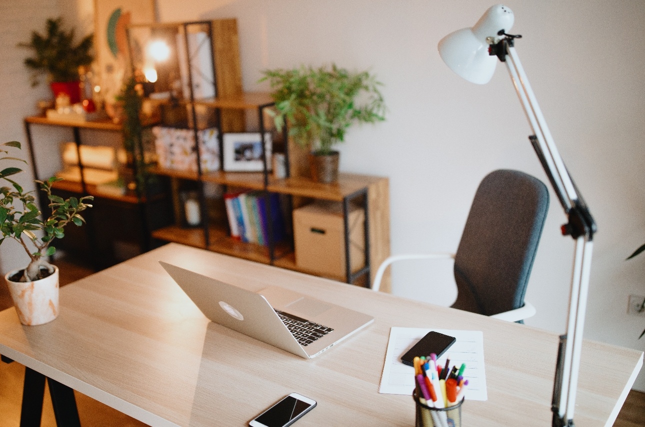 Laptop on white desk with white angle-poise lamp