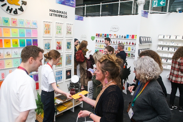 exhibition stand of stationery business with people visiting it 