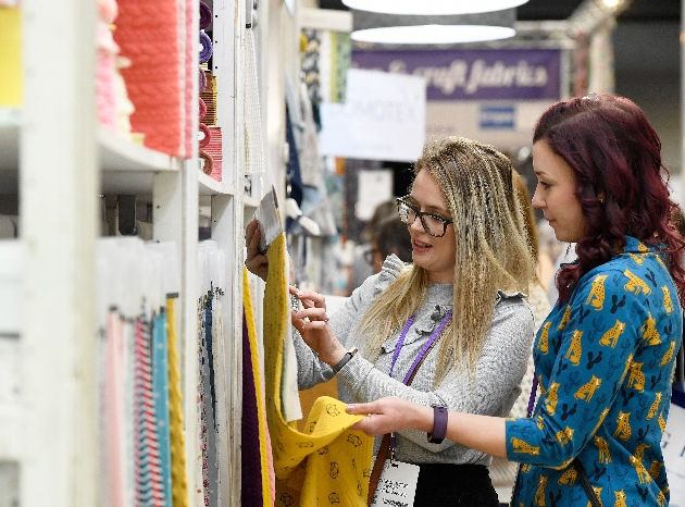 ladies looking at fabric at a trade show