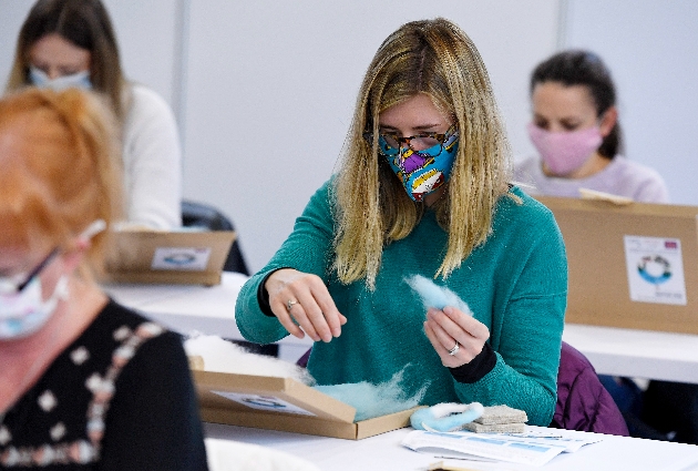 Lady in mask doing craft kit