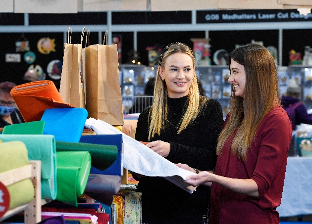 Ladies discussing fabric at exhibition show stand