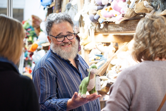 Exhibitor holding product at Giving & Living trade show