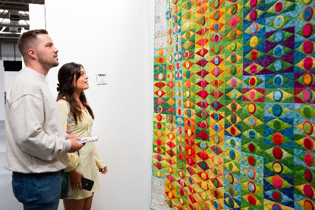 young couple looking at quilt at a trade show