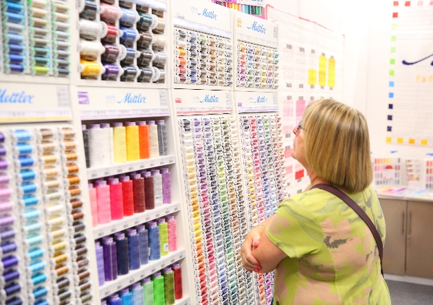 lady looking at threads at exhibition