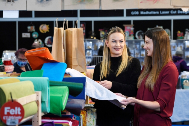 two ladies looking at rolls of felt