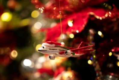 toy plane christmas decoration hanging off glowing tree