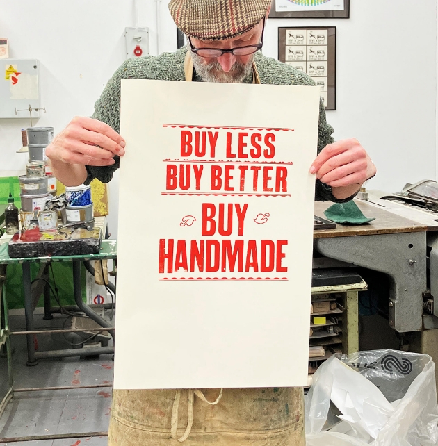 man holding buy handmade craft poster