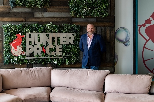 Man standing in front of green wall next to Hunter Price logo