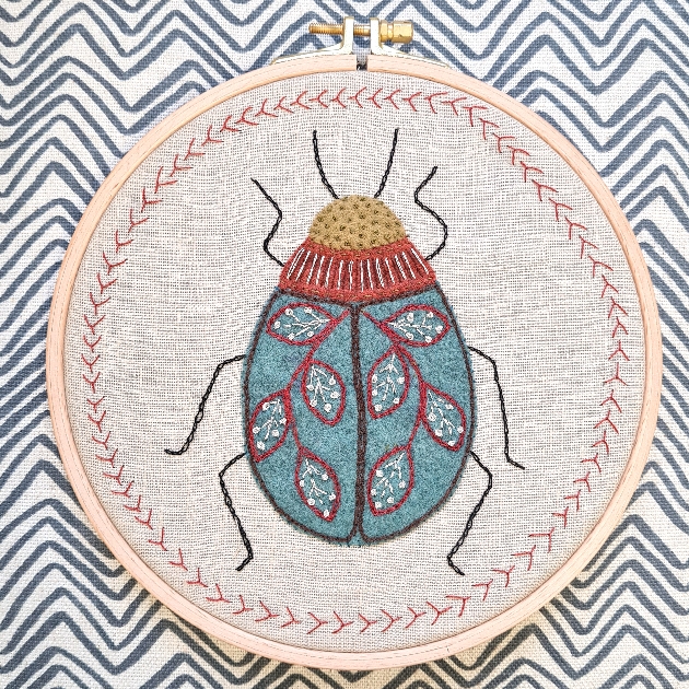 bug on a cross stitch frame