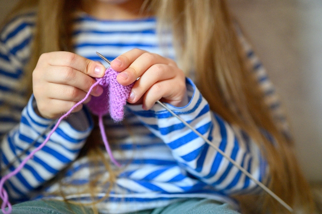 close up of lady knitting on train