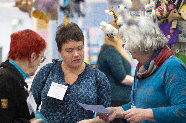 Women having a conversation around crafts. 