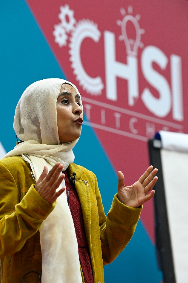 lady wearing cream hijab and yellow shirt presenting on a stage
