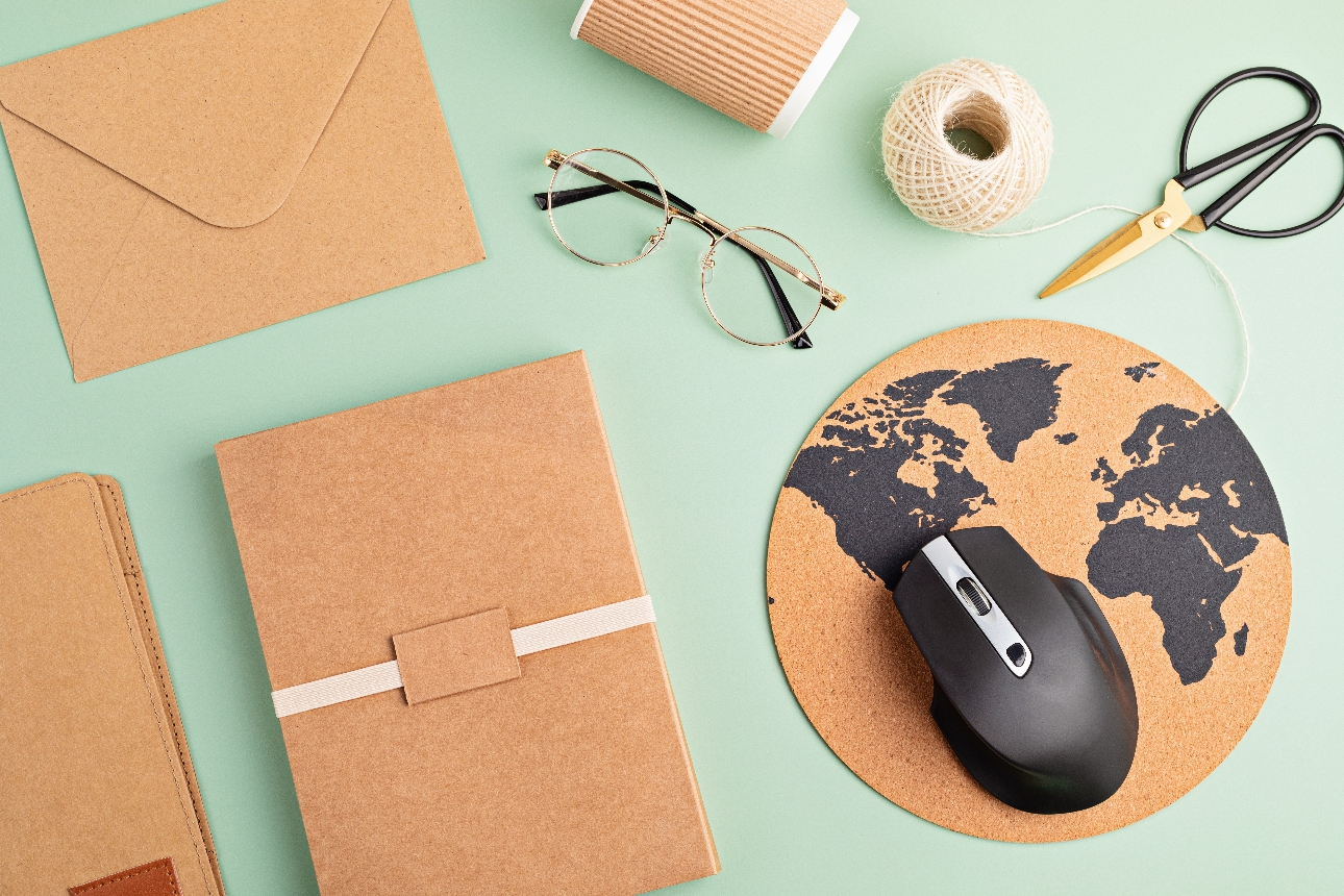 work desk with brown paper objects, sting, mouse and glasses 