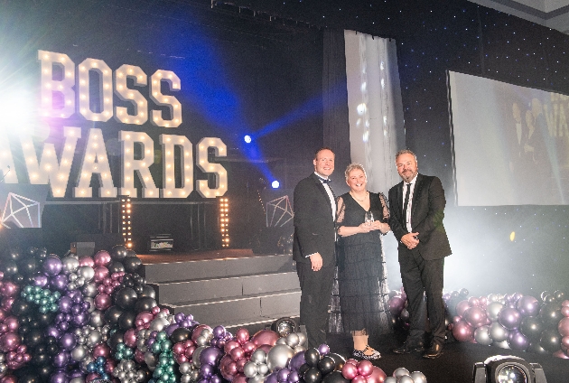 Lady and two men on stage at awards ceremony