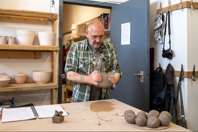 man kneading balls of clay