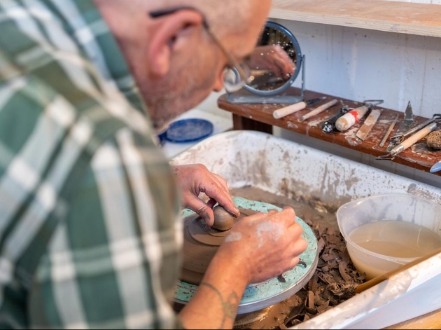 man working on pottery wheel