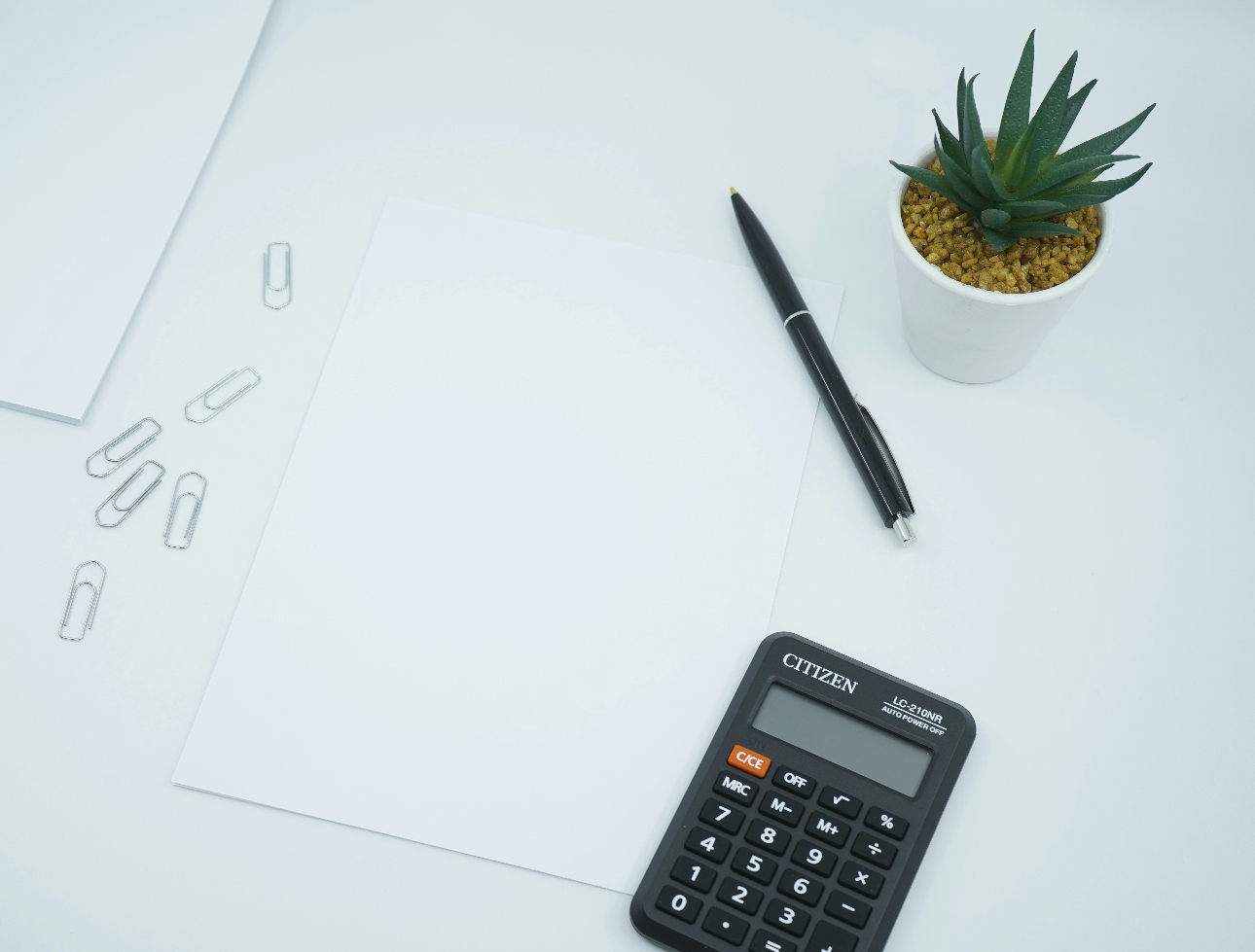 calculator on a desk with paperclips around it