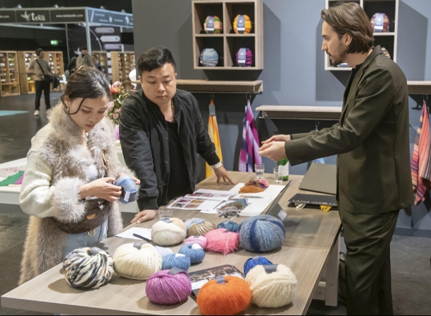 couple looking at yarn balls 