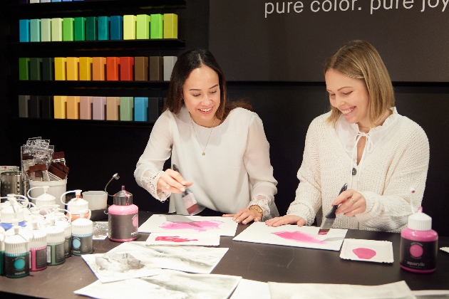Two ladies painting on white paper