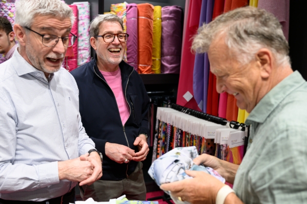 three men chatting about fabrics