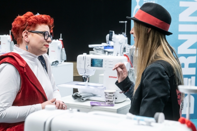 two ladies talking next to sewing machine