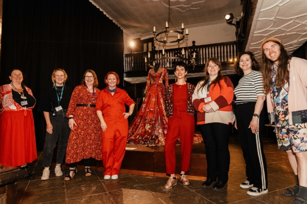 group of people standing in front of stage  in gallery