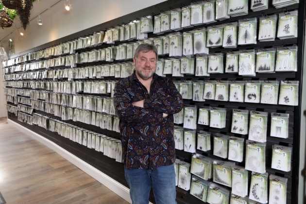 man standing in front of packets of polymer stamps