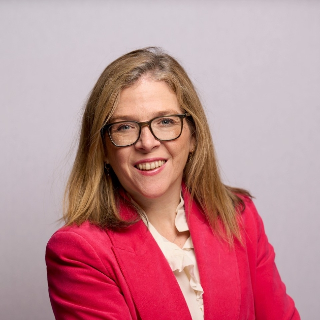 headshot of blonde woman with black glasses