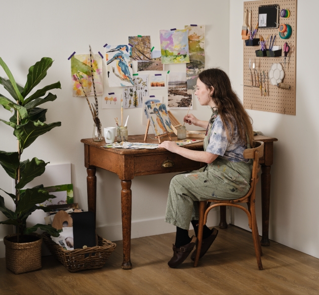 lady painting at wooden desk