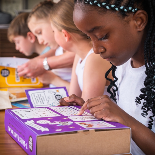 line of children looking at boxes of craft kits