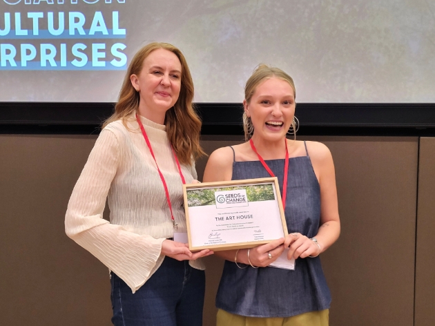 two women holding framed certificate