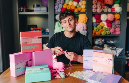 tom daley sitting at a craft table doing crochet