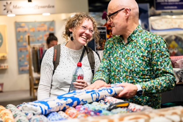 man and woman looking at fabric at a trade show